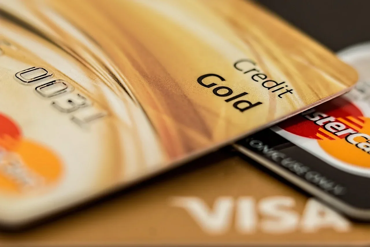 A close-up of stacked payment cards with the words Credit Gold and Visa visible on a desk.